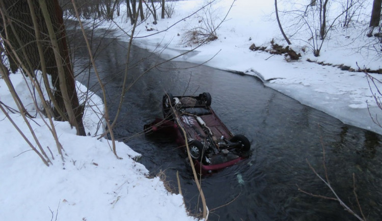 Řidička dostala na zledovatělé silnici smyk, její auto skončilo na střeše v řece