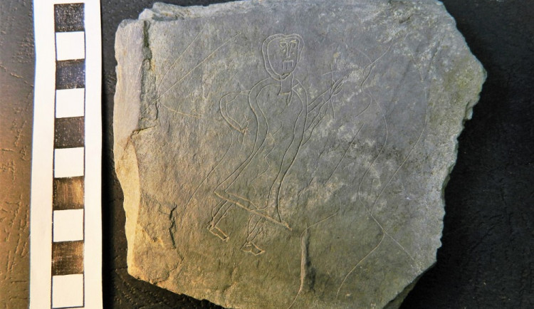 Archeologové našli na nádvoří děkanátu unikátní břidlicovou destičku s postavou nesoucí kříž