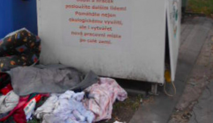 Vandal poškodil v centru města kontejner na oblečení. Oděvy se válely všude okolo