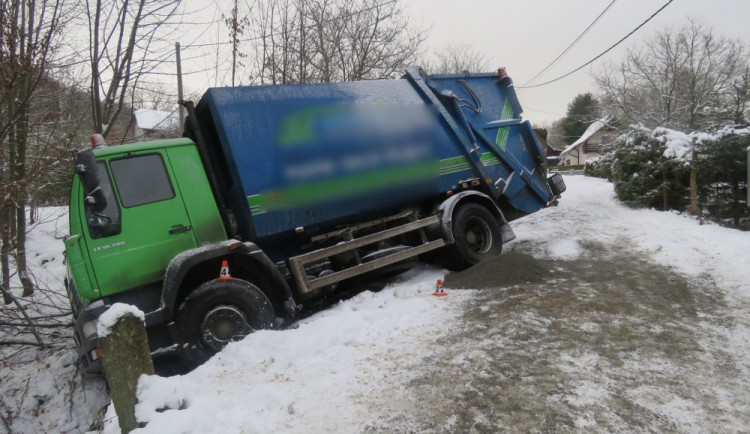 Řidič nezvládl udržet svůj náklaďák na zasněžené silnici, skončil s ním v příkopu vedle silnice
