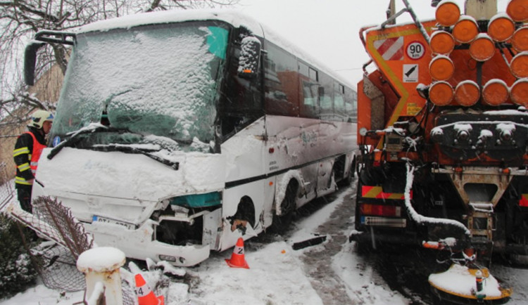 Autobus se srazil se sypačem a skončil v plotu rodinného domu, řidič byl převezen do nemocnice