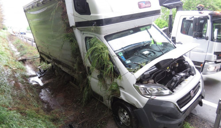 Řidič na dálnici sjel se svým náklaďákem mimo cestu, vůz skončil převrácený na boku