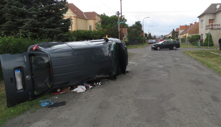 Dvě osobní auta se střetla v křižovatce, jedno z nich zůstalo po kolizi převrácené na boku