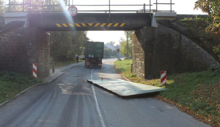 Řidič se s náklaďákem nevešel pod železniční most, o konstrukci urazil víko kontejneru