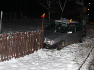 Opilý řidič nezvládl na letních gumách zatáčku a skončil v oplocení domu