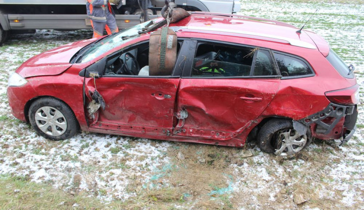 FOTO: Řidička přejela do protisměru, kde narazila do protijedoucího auta. To skončilo v poli převrácené na střechu