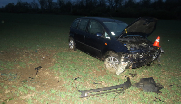 Dvě auta začala předjíždět ve stejný čas, jedno z nich dostalo smyk a skončilo v poli