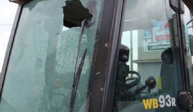 Vandal rozbil okno bagru zaparkovaného ve firemním areálu. Ve vězení si může posedět až rok
