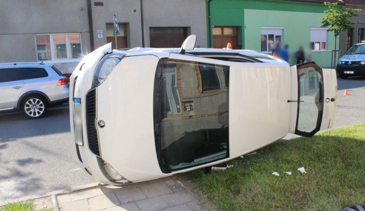 Žena bez řidičáku při couvání nabourala projíždějící auto. To skončilo na boku