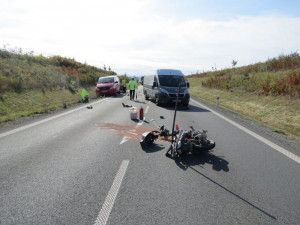 Motorkář se díval do zpětného zrcátka a přehlédl auto s přívěsem před ním. Po nárazu upadl na silnici