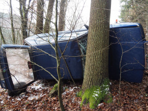 FOTO: Silně podnapilý řidič nezvládl průjezd zatáčkou, převrátil se ze svahu a narazil do stromu