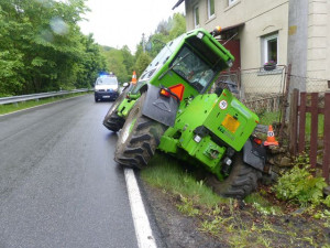 FOTO: Řidič zemědělského stroje sjel z cesty a opřel se o plot rodinného domu