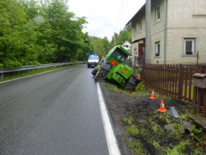FOTO: Řidič zemědělského stroje sjel z cesty a opřel se o plot rodinného domu