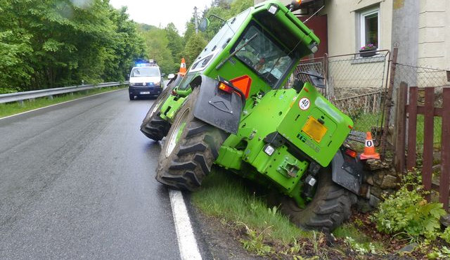 FOTO: Řidič zemědělského stroje sjel z cesty a opřel se o plot rodinného domu