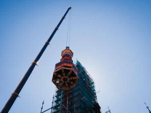 FOTO/VIDEO: Jeřáb dnes na olomouckou radnici vyzvedl prostřední část opravené věže