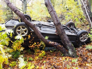 FOTO: Řidič nezvládl řízení, skončil v lese převrácený na střechu