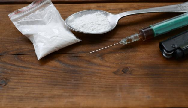 syringe-lighter-spoon-full-white-powder-wooden-background-heroin-drug-addiction-concept_76080-16843